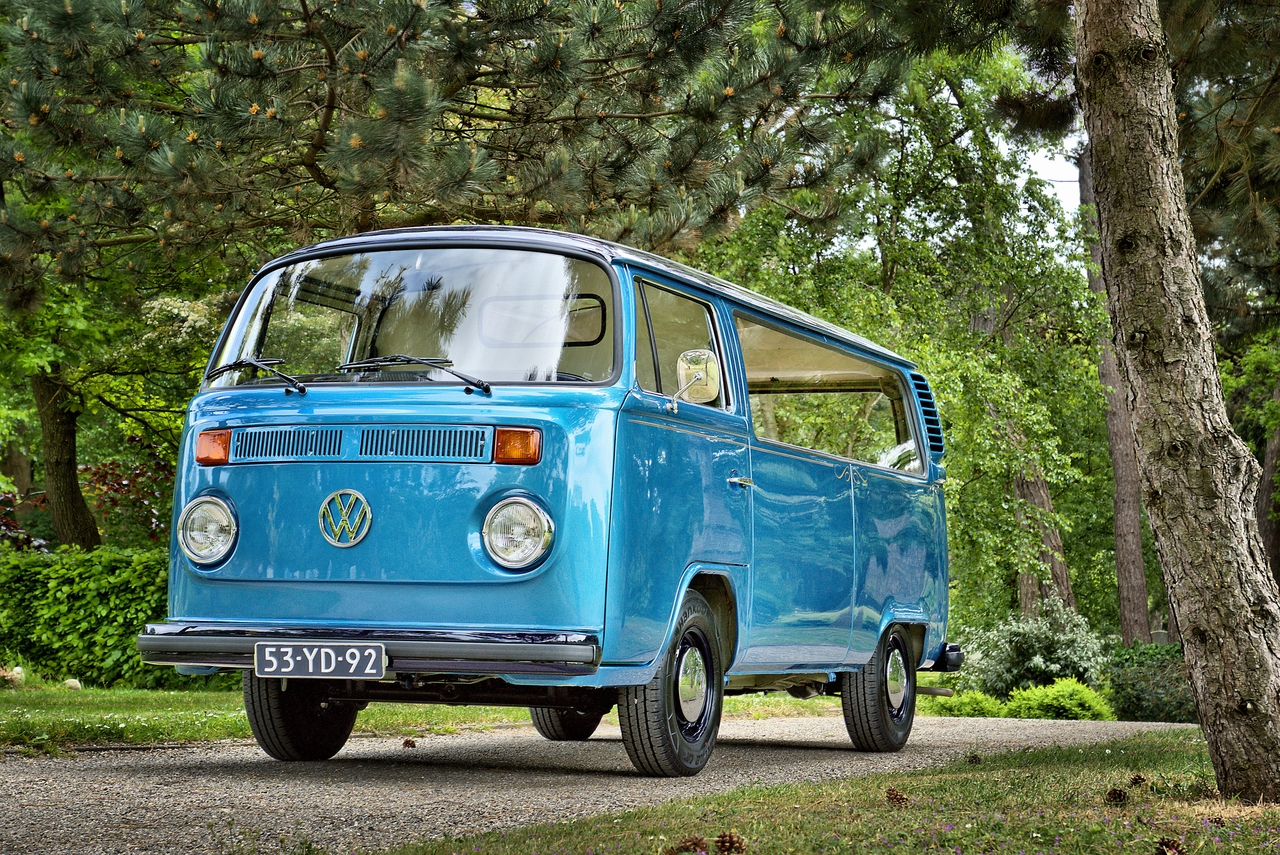 Blue rebuild VW Van to hearse in sunny graveyard with trees